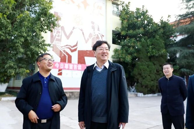凉山州民族中学苏解放校长(左)在向王涛书记介绍学校情况